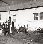 Barry Williams hanging onto water pump with visitors at Tarnagulla C1966